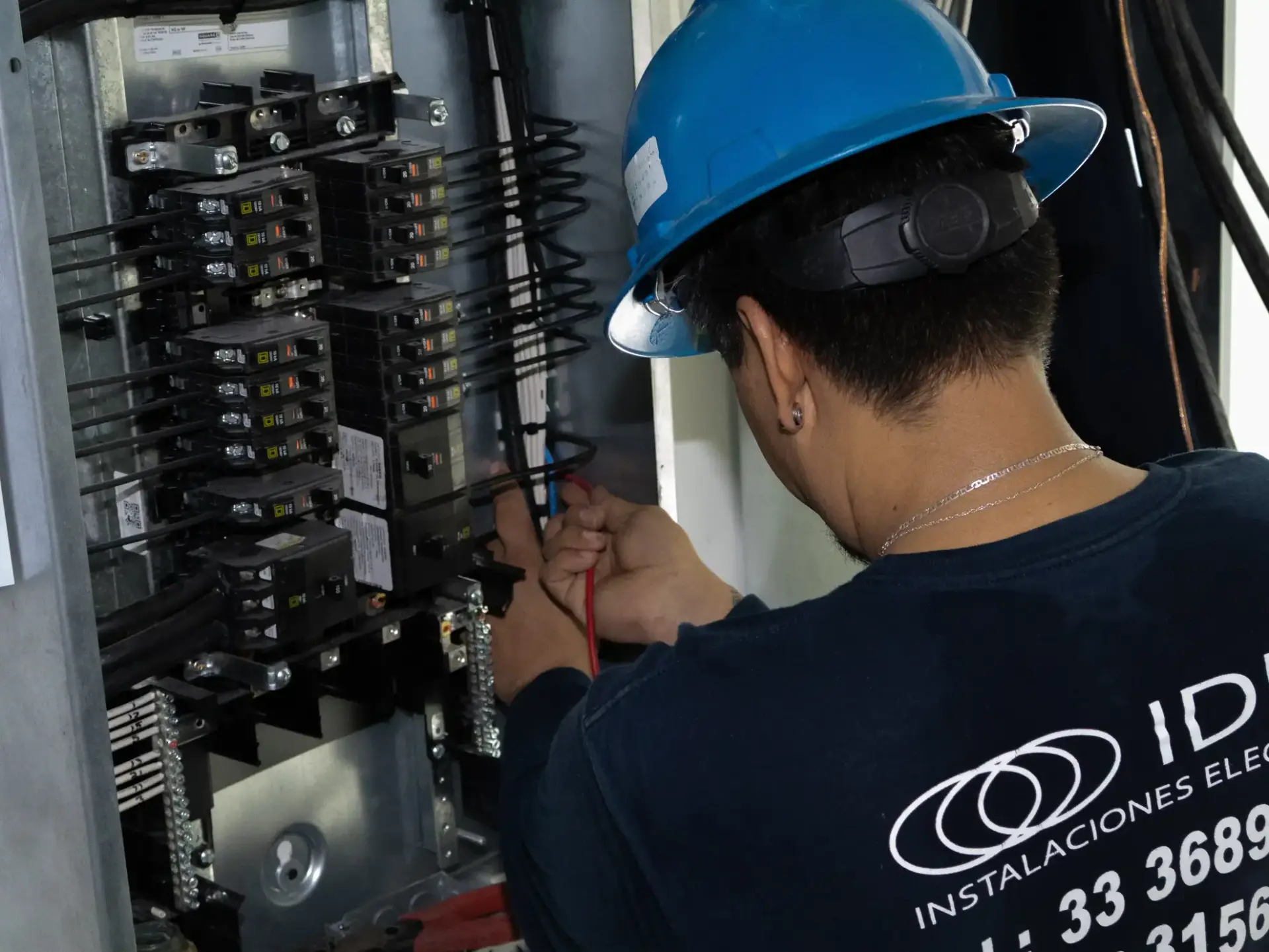 Técnico instalando tablero de distribución eléctrica
